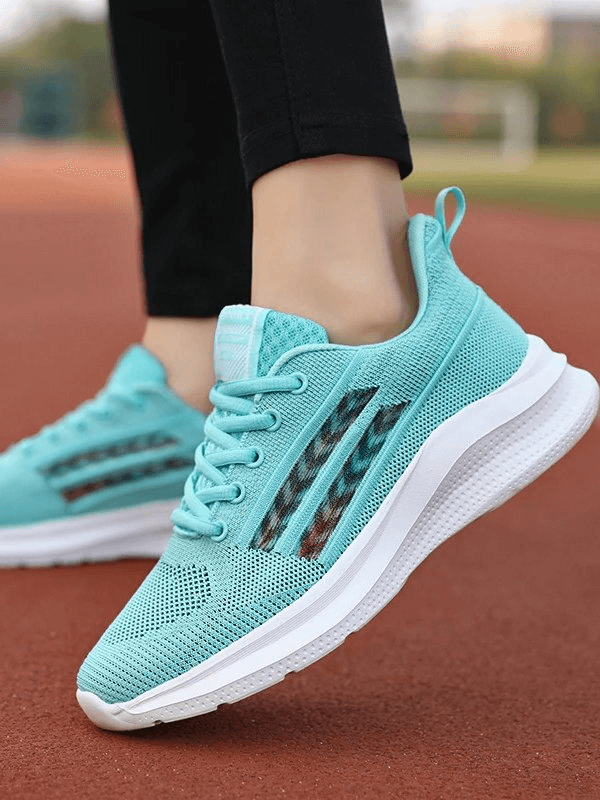 Turquoise mesh women's training shoes with EVA outsole, breathable fabric, and lace-up design on a running track.